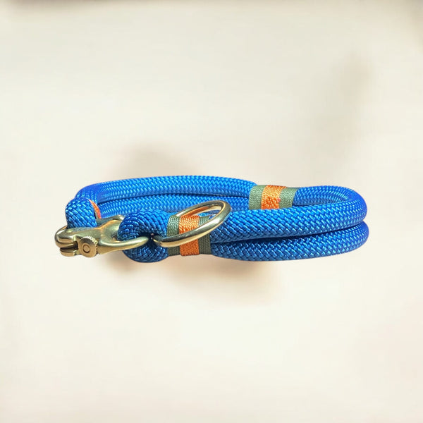 Side profile of the Greenwich Yarn Soho Edition handmade rope dog collar in petrol blue, featuring olive drab and burnt orange nano yarn wraps with solid brass sailing shackle and o-ring.