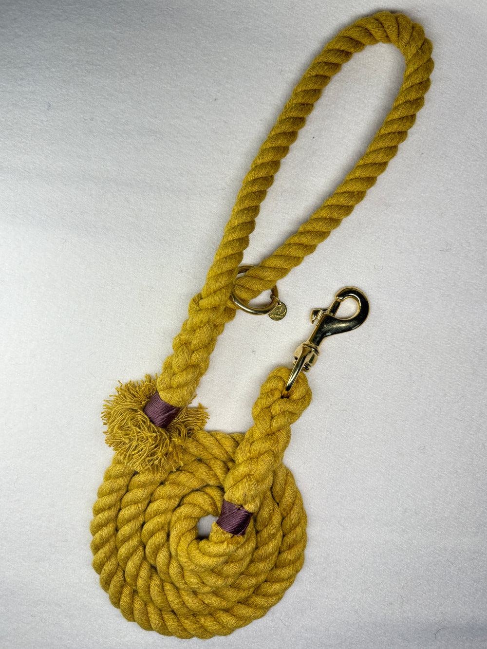 Mustard Yellow Cotton braided rope dog lead with brass hardware on a light woollen background