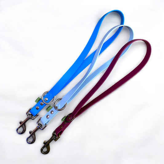 Three short handle BioThane traffic leads in classic blue, pastel blue, and maroon, ideal for training and harness control.