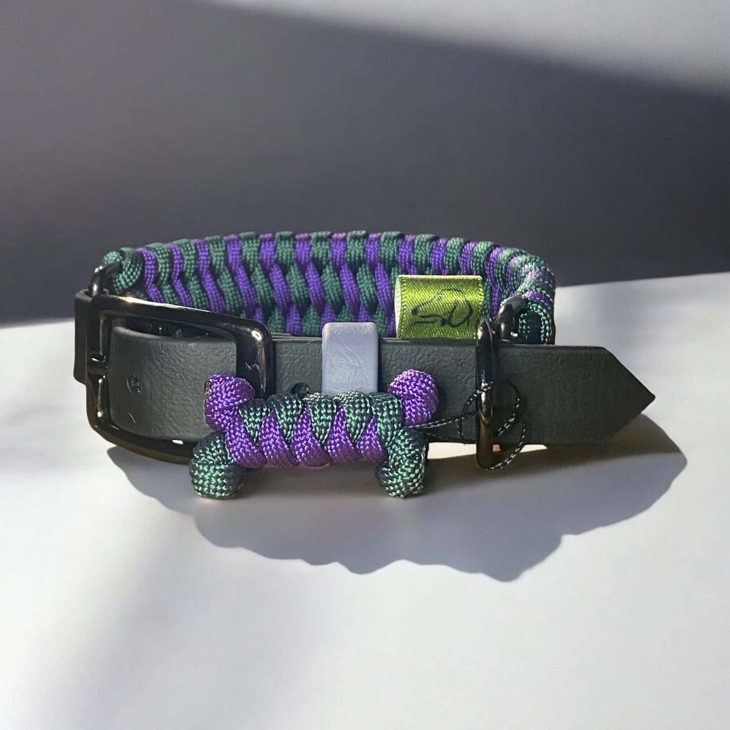 Close-up of the adjustable Centre Court dog collar featuring Alpine Green and Deep Purple tones with a black BioThane adjustable strap.