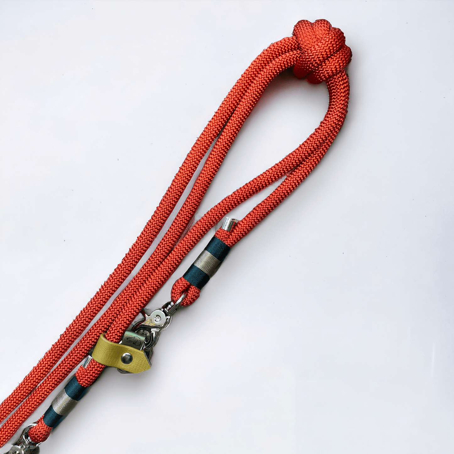 Close-up of Greenwich Yarn handsfree dog lead featuring poppy red rope, alpine green and tan nano binding, and nickel hardware.