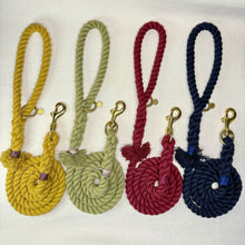 The Cotton Mill braided rope dog leashes in mustard yellow, olive green, burgundy, and midnight blue on a white woollen background