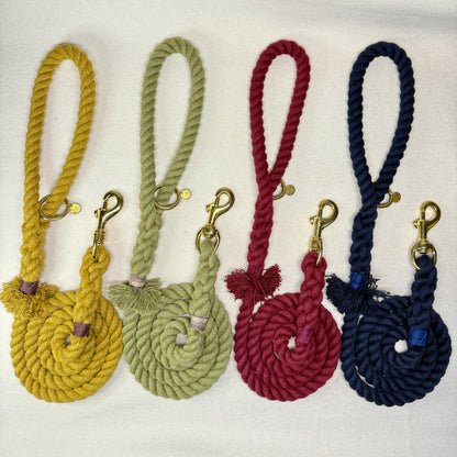 The Cotton Mill braided rope dog leashes in mustard yellow, olive green, burgundy, and midnight blue on a white woollen background
