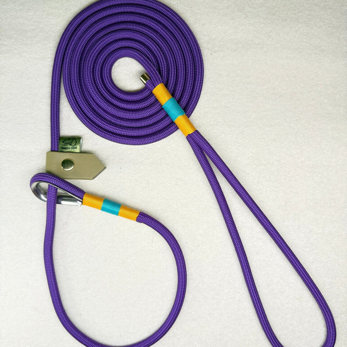 Deep purple 6mm rope slip lead for dogs with airforce gold primary nano binding, teal accent nano binding, and a beige adjustable BioThane slider, handcrafted to order.