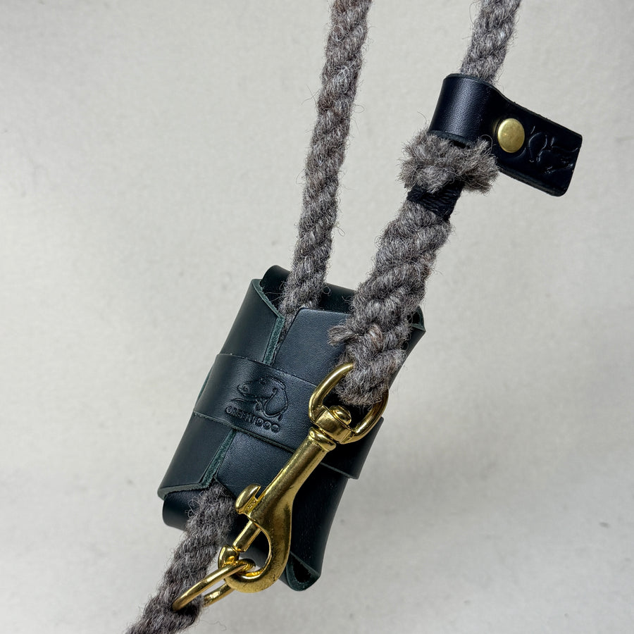 Hunter green leather poo bag holder hand embossed with the Green Dog mark, fastened to a wool rope dog lead with a solid brass trigger clip