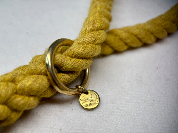 Mustard Yellow Cotton braided rope dog lead close up with brass hardware on a light woollen background