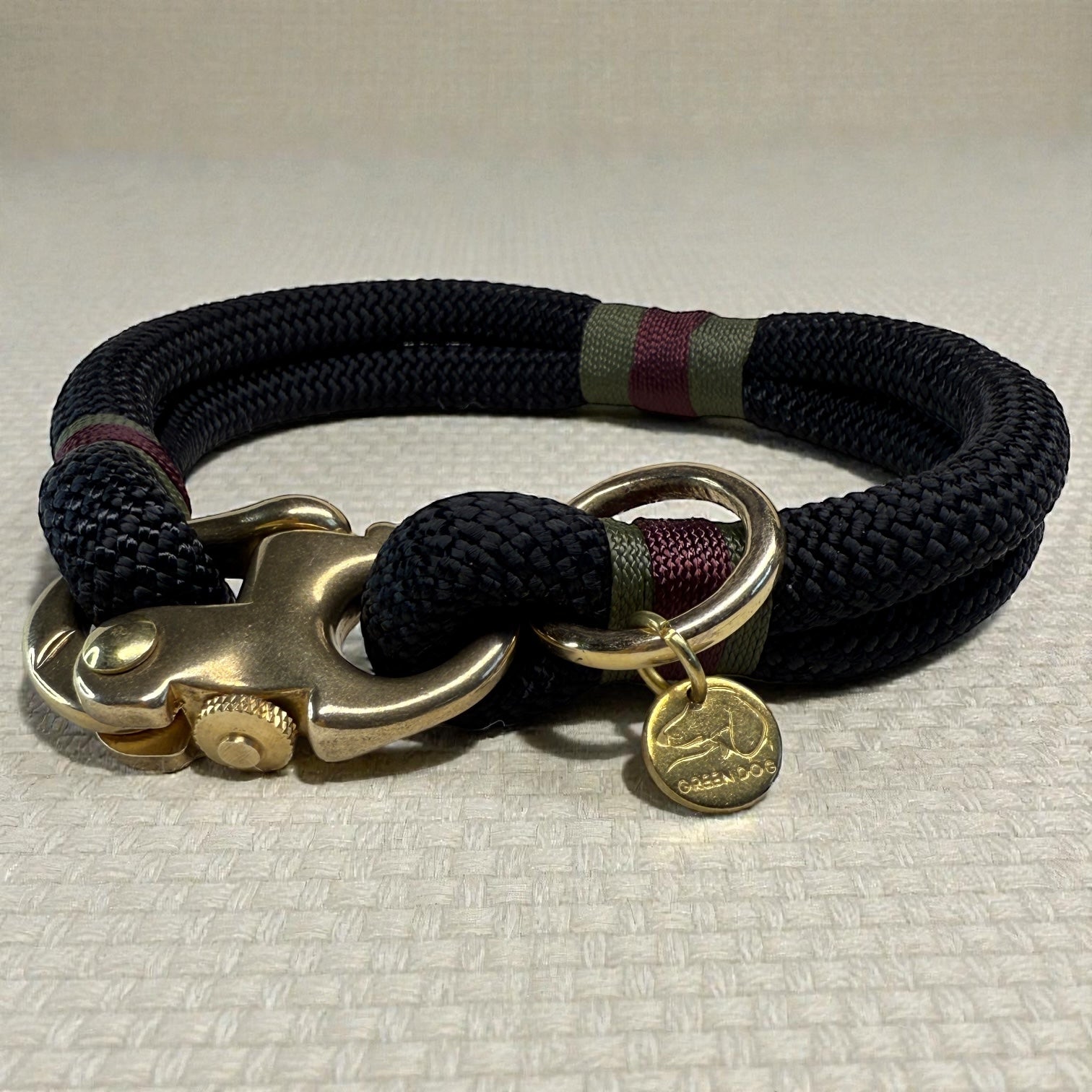 A close up side profile of the midnight edition greenwich yarn dog collar with olive drab, maroon bound detail and solid brass hardware