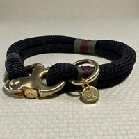 A close up side profile of the midnight edition greenwich yarn dog collar with olive drab, maroon bound detail and solid brass hardware