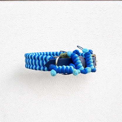 Side profile view of the Sunny Sky Adjustable Cord Dog Collar, showcasing the Navy Blue BioThane adapter, Sky Blue and Royal Blue cords, nickel hardware, and 3 signature bone tassel charms.