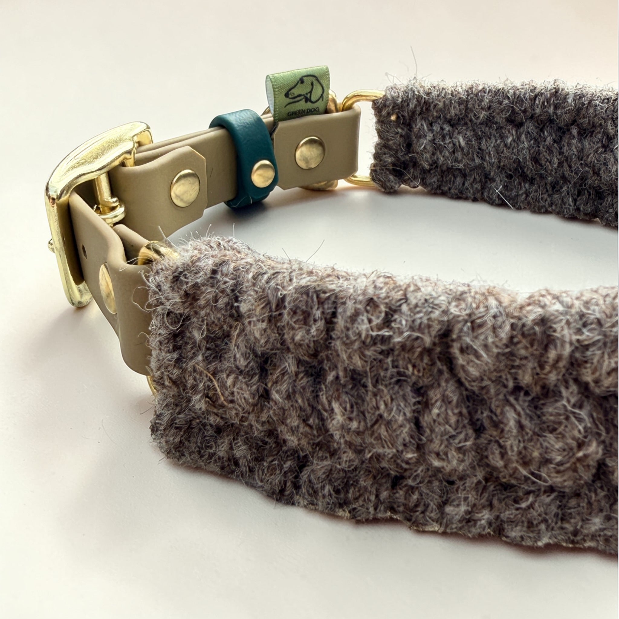Close-up of Brampton heritage wool weave on the Brampton Hybrid dog collar — grey British wool in 3-row weave showing natural fibre texture, beige BioThane strap and solid brass buckle visible, Sheep Shed Hybrid collection


Image 19 (IMG_6229) — HARDWARE CLOSE-UP
Tight low-angle shot showing the D-ring, Green Dog woven label, teal keeper and buckle end all together. Best hardware detail across the collar shots.

File title: brampton-hybrid-collar-biothane-hardware-detail-green-dog.jpg
Alt text: Detail of B