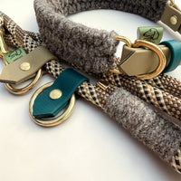 Extreme close-up of Brampton Hybrid rope lead detail — teal BioThane loop tab with solid brass rivet and O-ring, grey Brampton wool binding on chestnut PPM rope, collar beige BioThane strap and brass D-ring visible behind