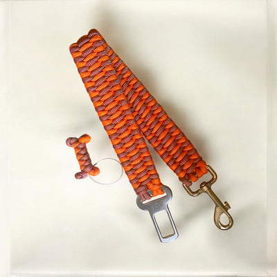 Canine Seat Belt | Paracord Dog Seat Belt for Car Travel - Green Dog using Red and Gold paracord and burnt orange paracord with a matching bone tassel