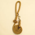 Harvest yellow handmade cotton rope dog lead coiled flat lay, with brass snap clip, brass O-ring, green dog charm tag and purple binding detail