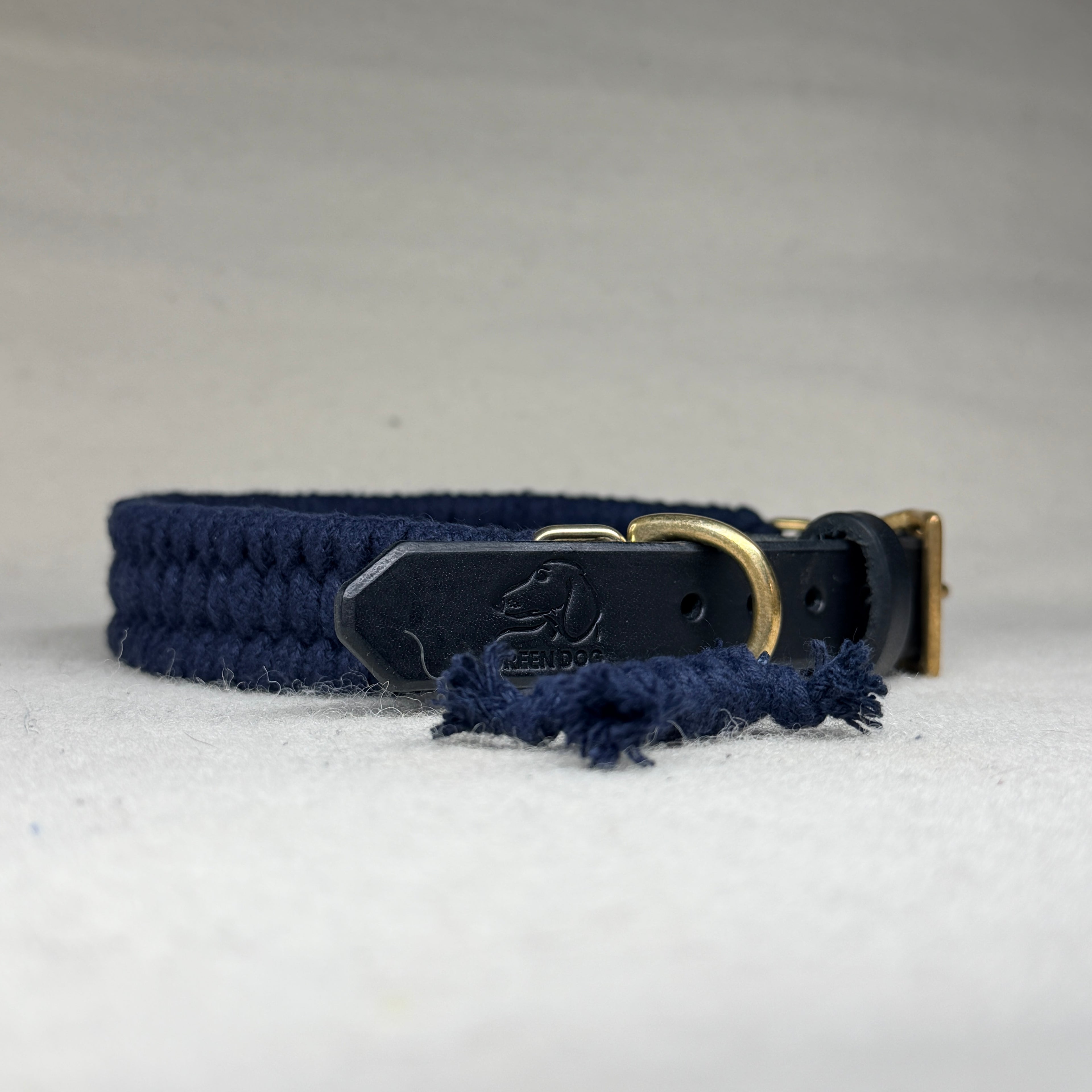 Back view of midnight blue cotton dog collar showing black veg-tanned leather strap, solid brass buckle and brass double-cap rivets
